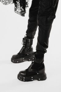 Close-up of stylish black platform boots and lace detail in a studio.