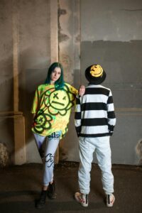 Edgy street fashion featuring vibrant graffiti designs in an urban setting.